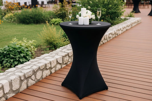 Black cocktail table with candles and glasses on a wooden deck
