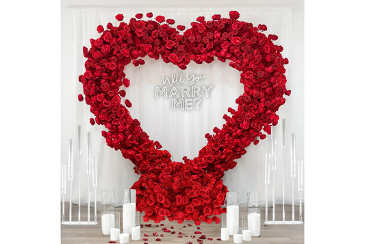 Will you marry me neon sign hanging from red rose heart.