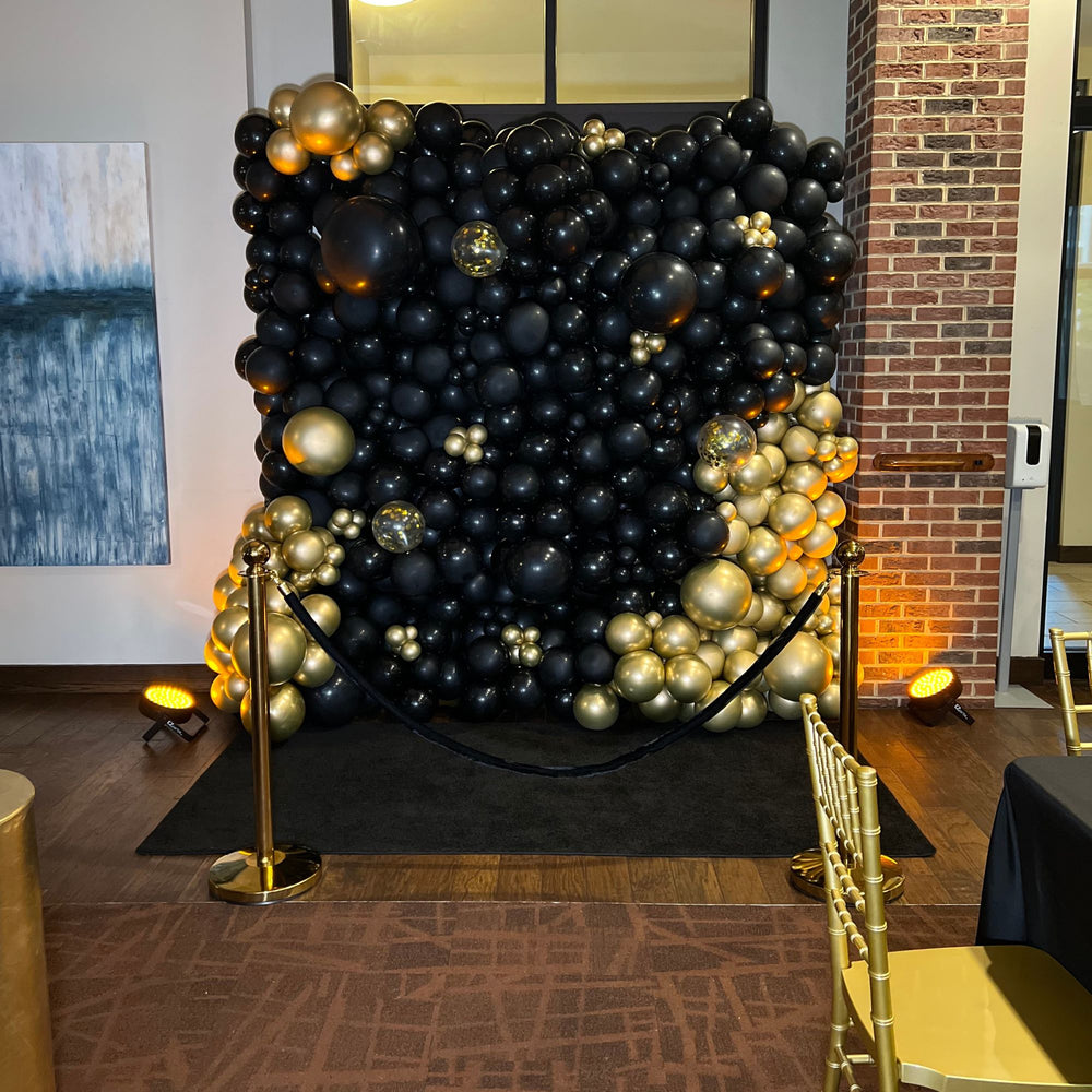 Black and gold organic balloon wall with confetti accent balloons