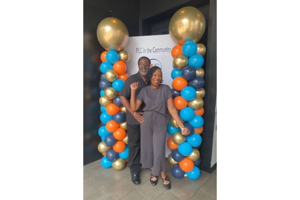 Colorful balloon columns with branded backdrop for a corporate event.
