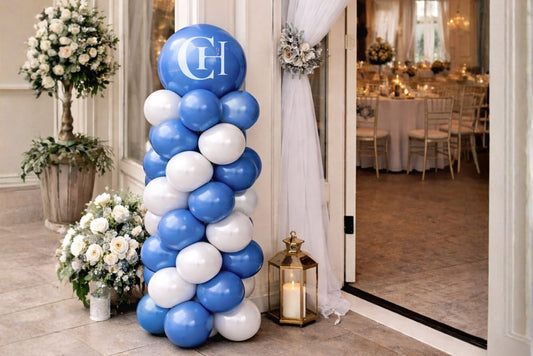 blue and white balloon column with monogram logo on topper balloon.
