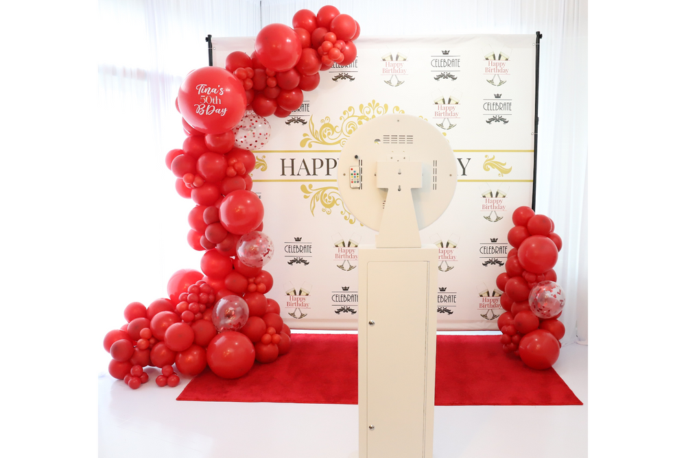 Happy birthday step and repeat banner with red personalized balloon garland and photo booth.