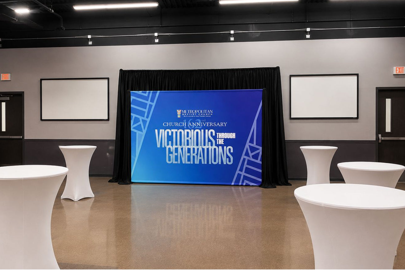 Event space with a step-and-repeat banner displaying 'Victorious Generations' in a room with white tables and chairs.