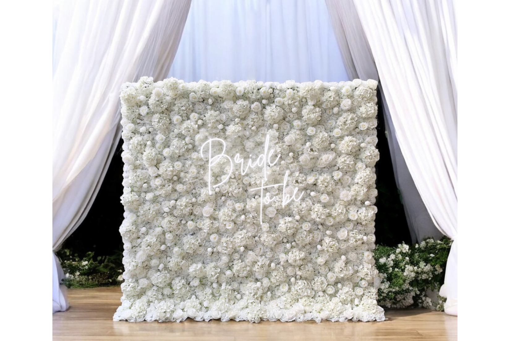 Off-white flower wall with white pipe and drape backdrop.